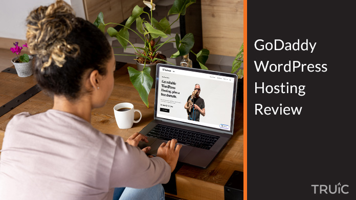 Woman on a computer looking at GoDaddys WordPress Hosting page.