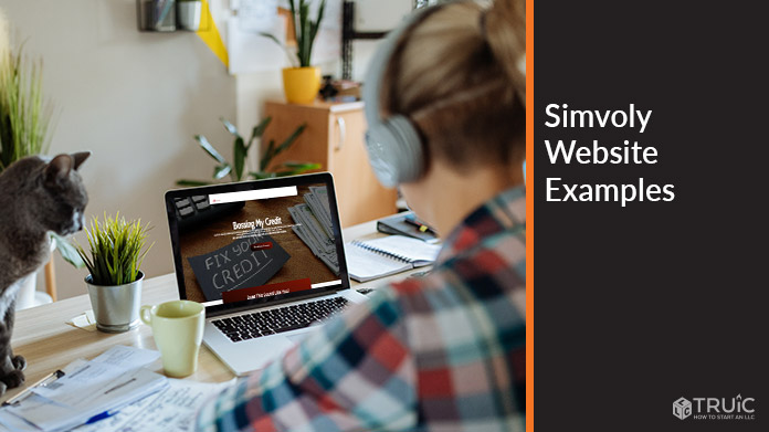 Person working on a computer with an example of a Simvoly website on it.
