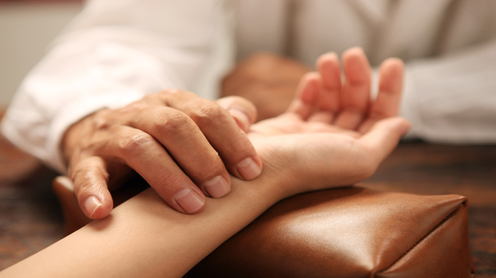 A doctor checking a patient pulse
