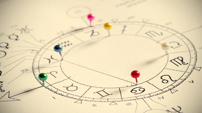 A zodiac chart with colorful pins in it