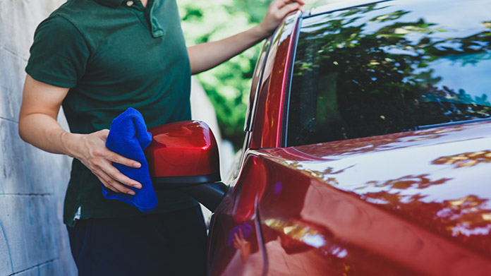 person drying off a car after a cash wash