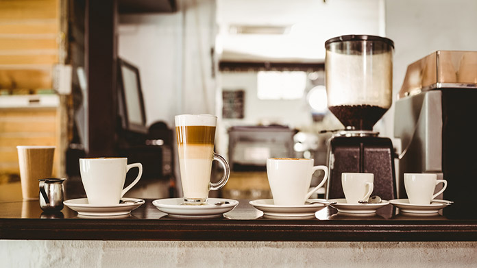 A coffee shop bar with multiple mugs of coffee