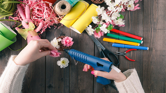 A person hot gluing fake flowers together