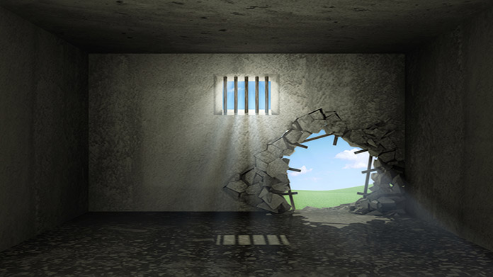 A prison cell with a whole burst through it
