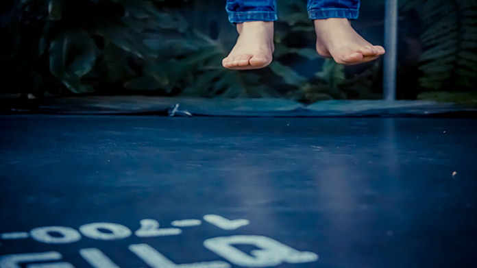 A pair of feet jumping on a trampoline