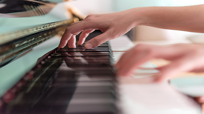 person learning how to play piano