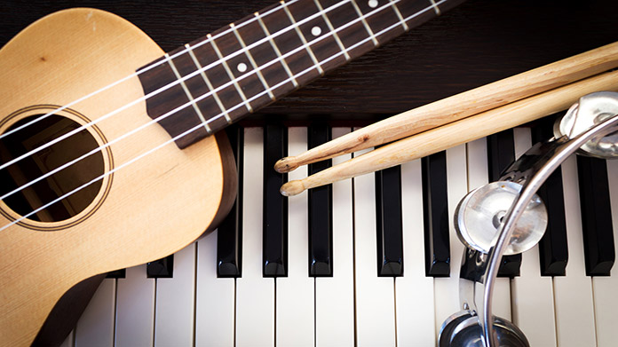 a variety of musical instruments; a guitar, drum sticks. piano, and tambourines