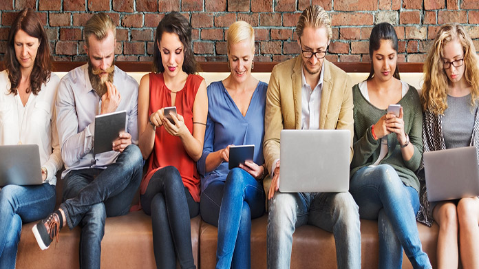 A row of people reading digital media