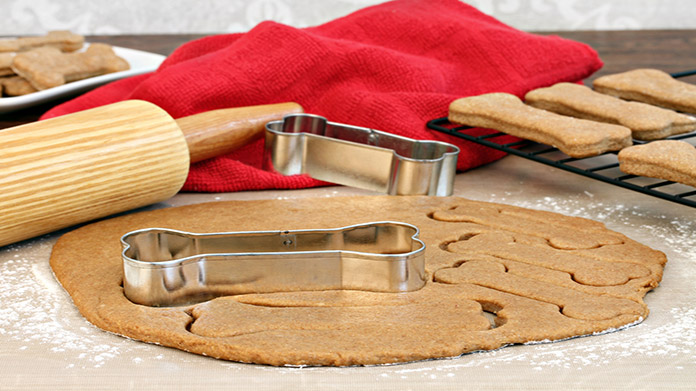 Dough being cut into bone shapes