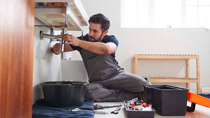 Plumbing handyman putting together plumbing hardware
