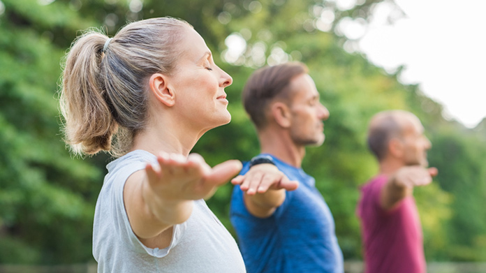 Three people performing yoga in a retreat