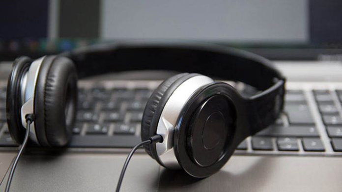 A set of headphones resting on a laptop