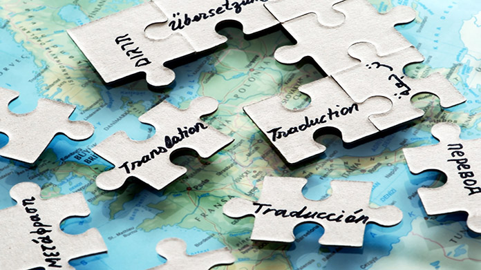 Puzzle pieces with translation written in different languages scattered on a map