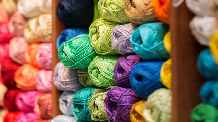 A wall rack of various yarn colors