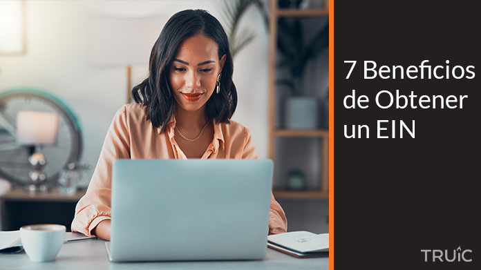 Una emprendedora lee en su computadora sobre los beneficios del EIN para su empresa.