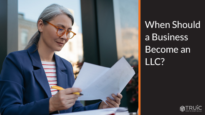 Smiling entrepreneur reviewing LLC documents.