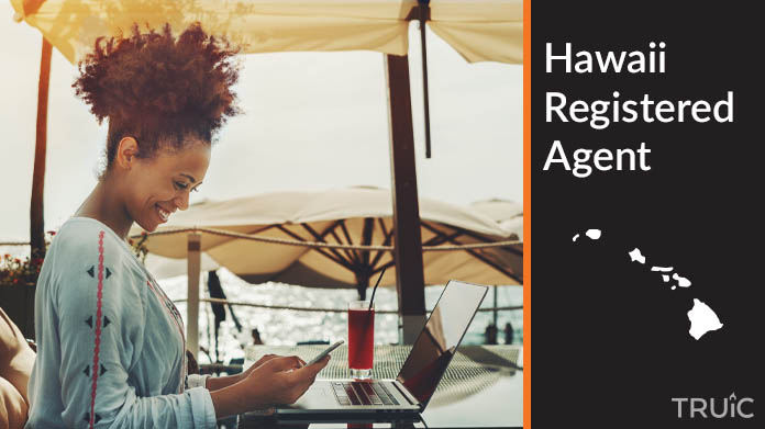 A person happily working remotely at a beach while their registered agent service takes care of business