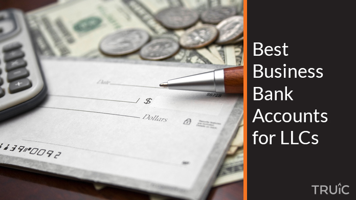 A checkbook, calculator and money on a table.