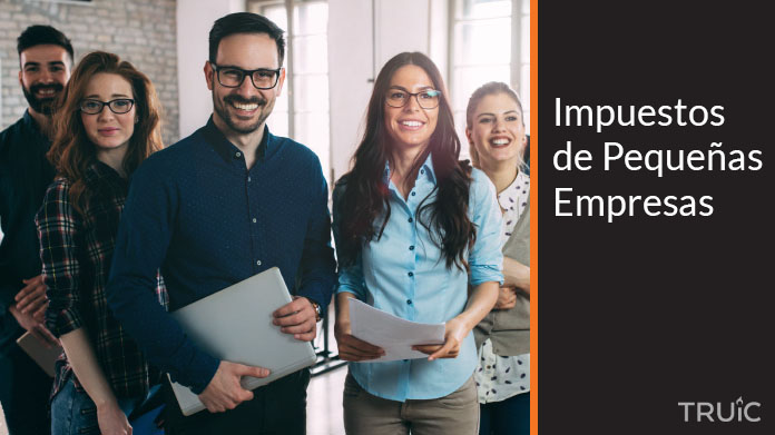 Un grupo de emprendedores de pequeñas empresas sonriendo con sus documentos en mano.